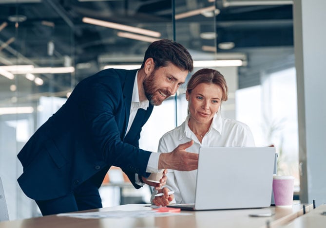 Empréstimo Mercado Pago: Gestores de empresa em sala de reunião olhando algo em notebook