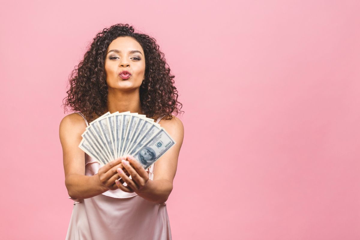 Mulher com notas de dinheiro na mão, representando organização financeira