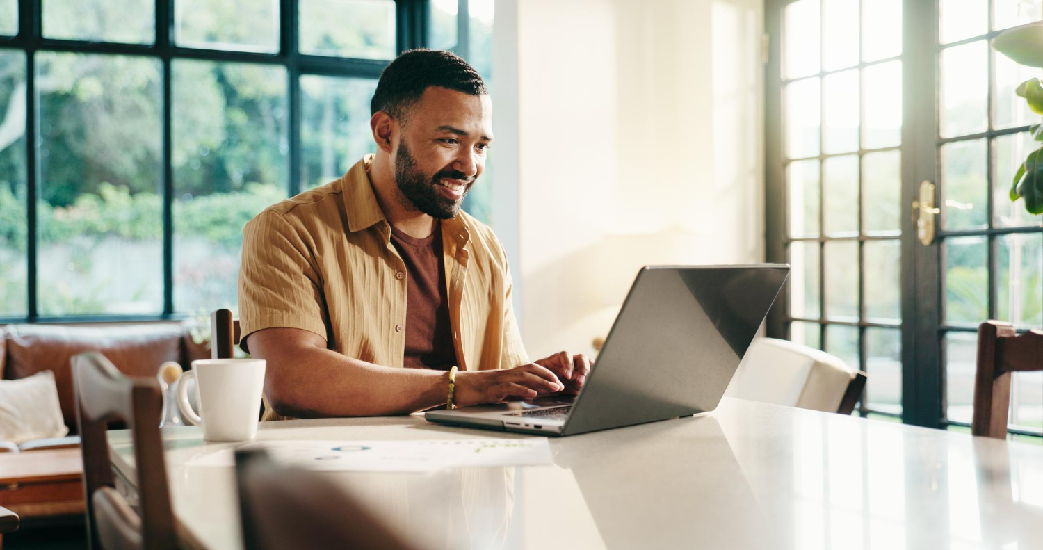 Freelancer sorridente trabalhando em notebook em home office