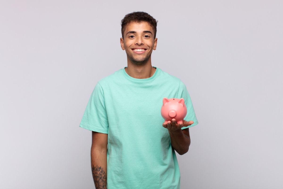 Homem jovem segura cofre por estar aprendendo sobre compras inteligentes