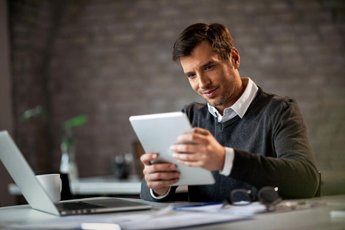 Homem analisa opções de financiamento para empresas em um tablet.