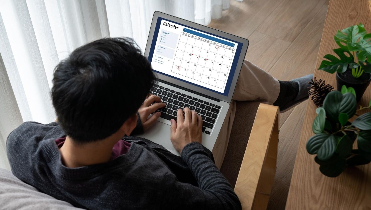 Homem com computador anotando em agenda o prazo de declaração do IR