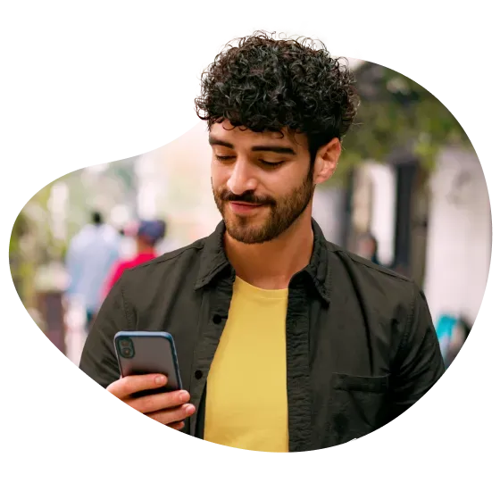 Una persona usa Mercado Pago en su celular mientras sonríe.