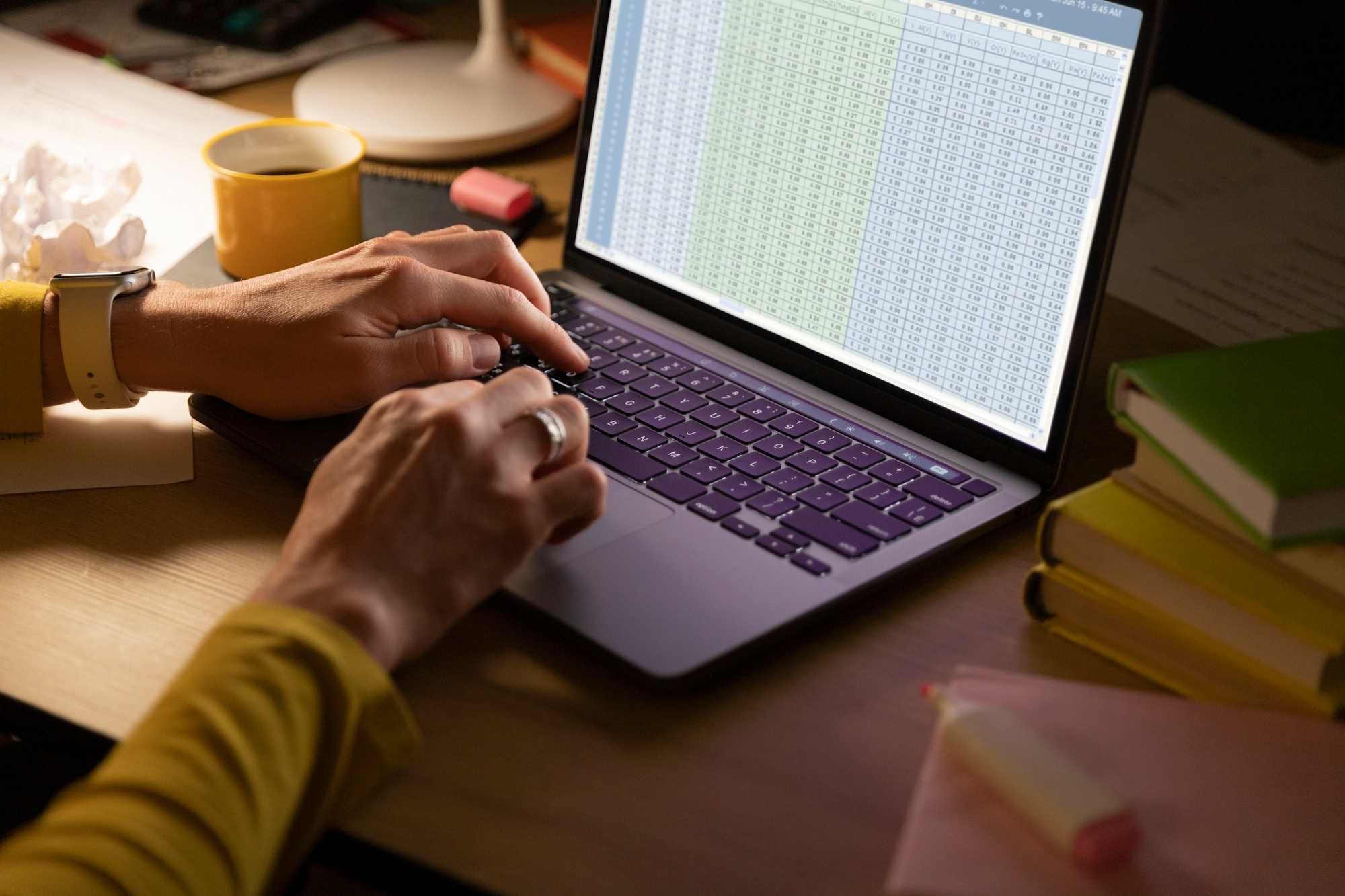 Mãos digitando em laptop com planilha financeira empresarial de gestão de caixa