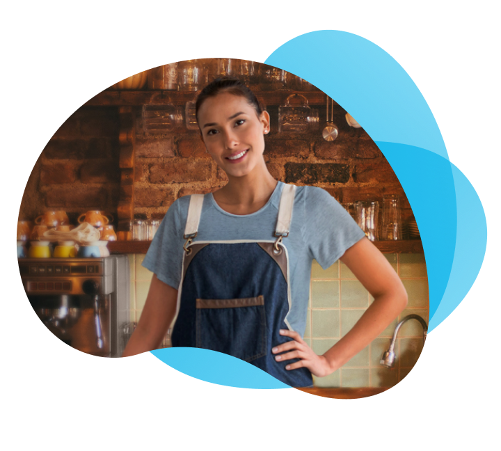 Mujer con un delantal azul, sonriendo en una cocina