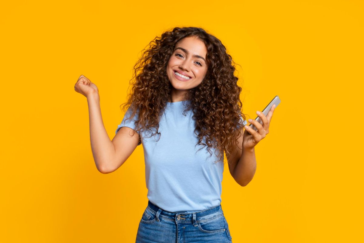 Mulher feliz pois consultou seu app Mercado Pago e tem saldo em conta