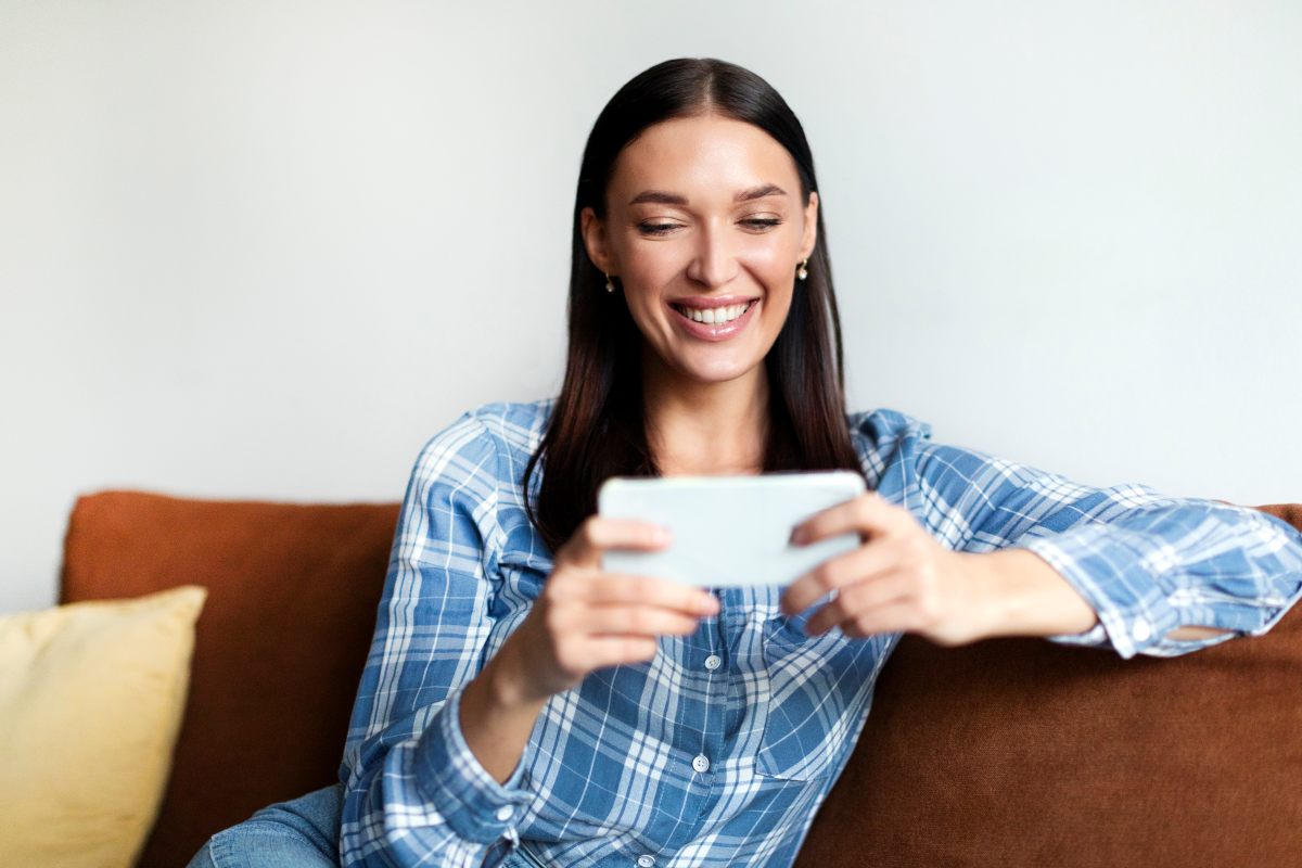mujer-sonriente-mira-pantalla-de-celular