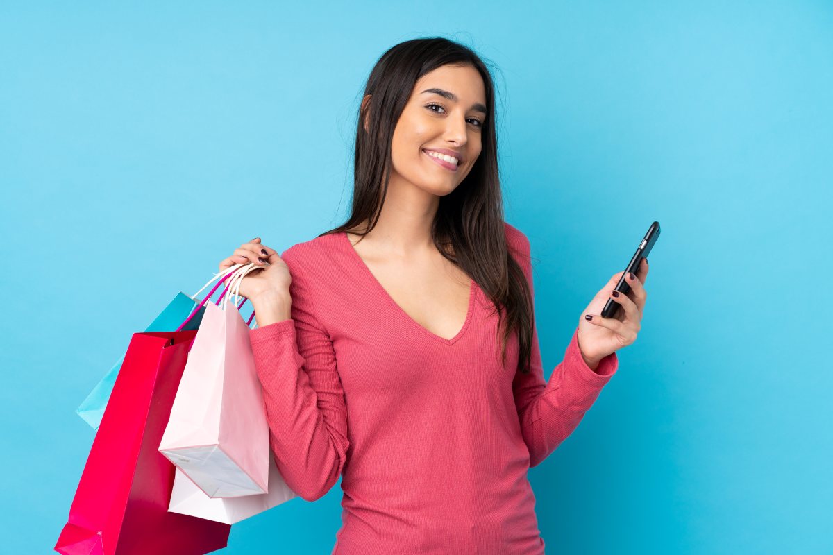 mujer-sostiene-bolsas-de-compras-y-celular