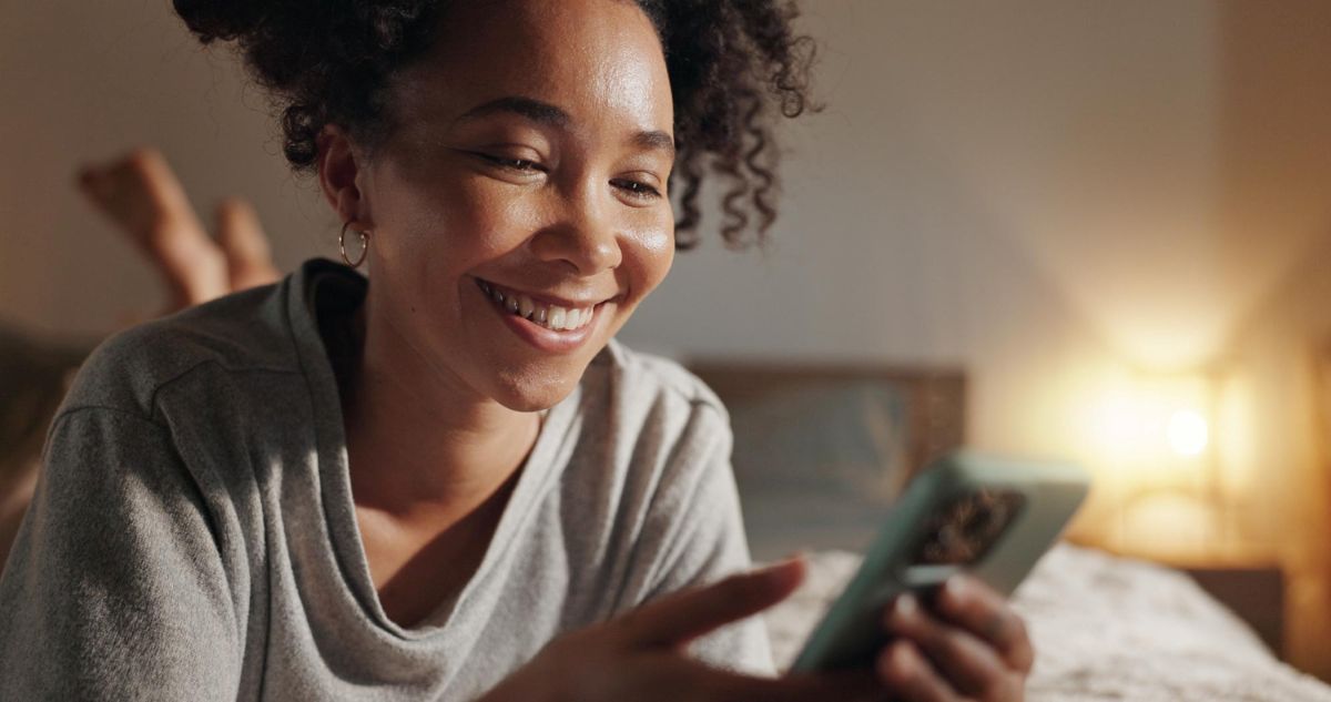 Mulher usando celular para contratar o seguro Mercado Pago