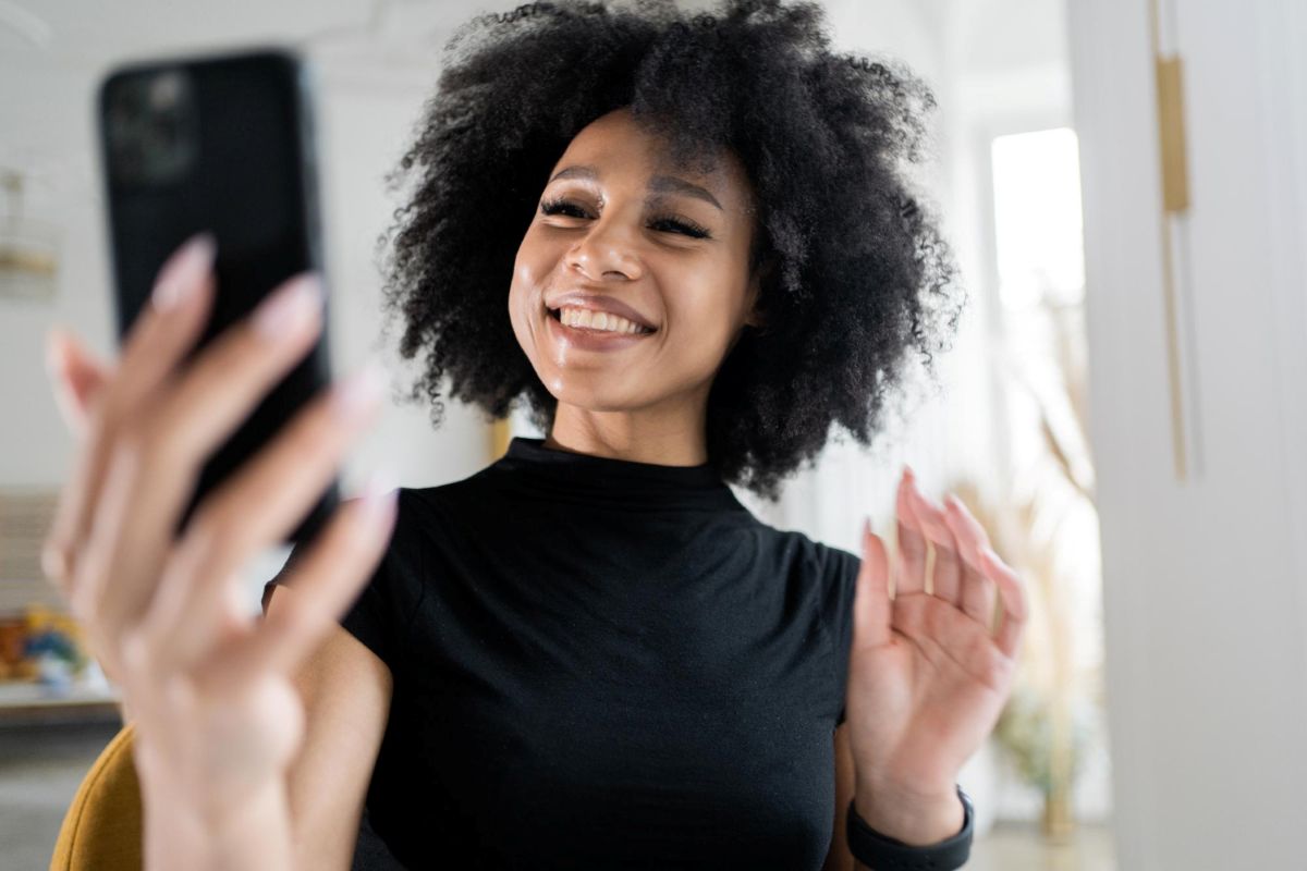 Mulher usa celular para fazer verificação de segurança com selfie