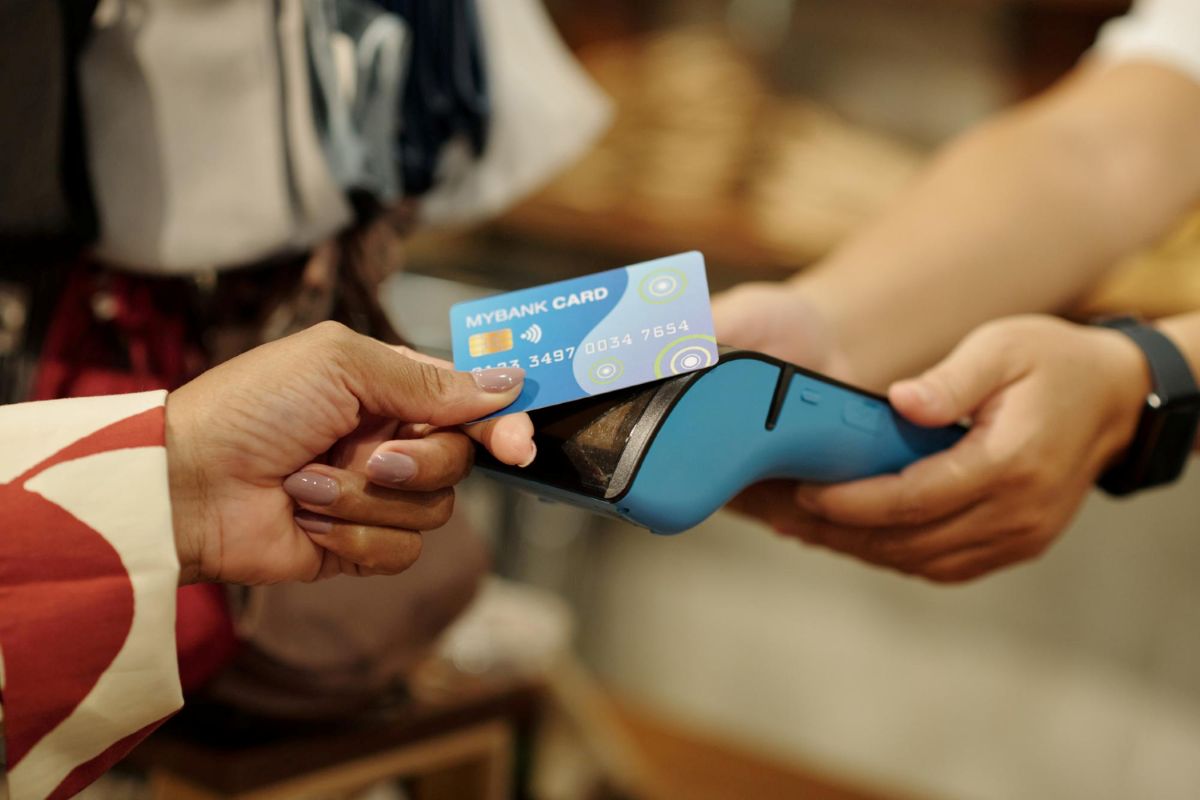 Pessoa paga com voucher em maquininha de cartão
