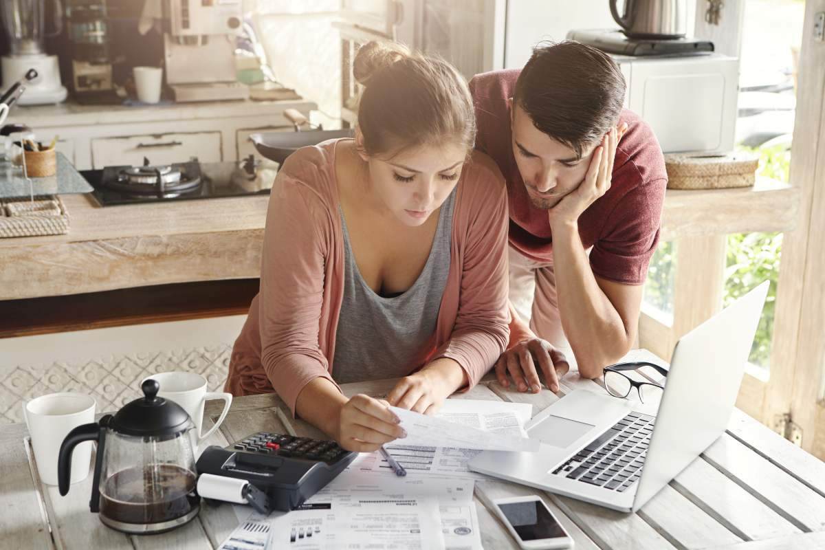 pareja-analiza-papeles-con-laptop-calculadora