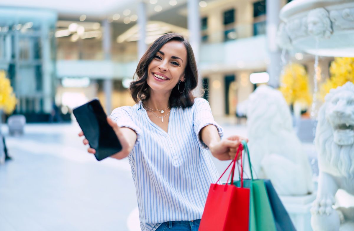 persona-feliz-con-bolsas-de-compras-y-celular