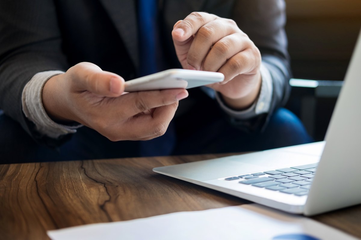 persona-frente-a-laptop-con-el-celular