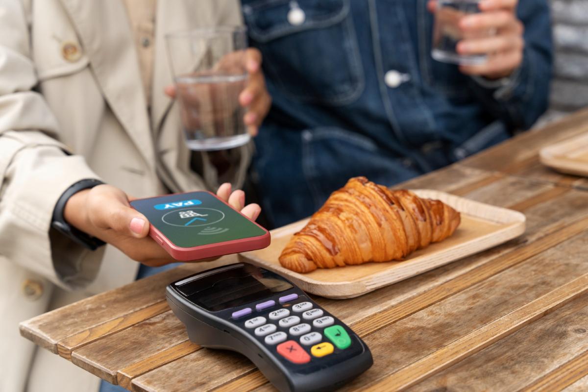 persona-pagando-con-celular-en-negocio