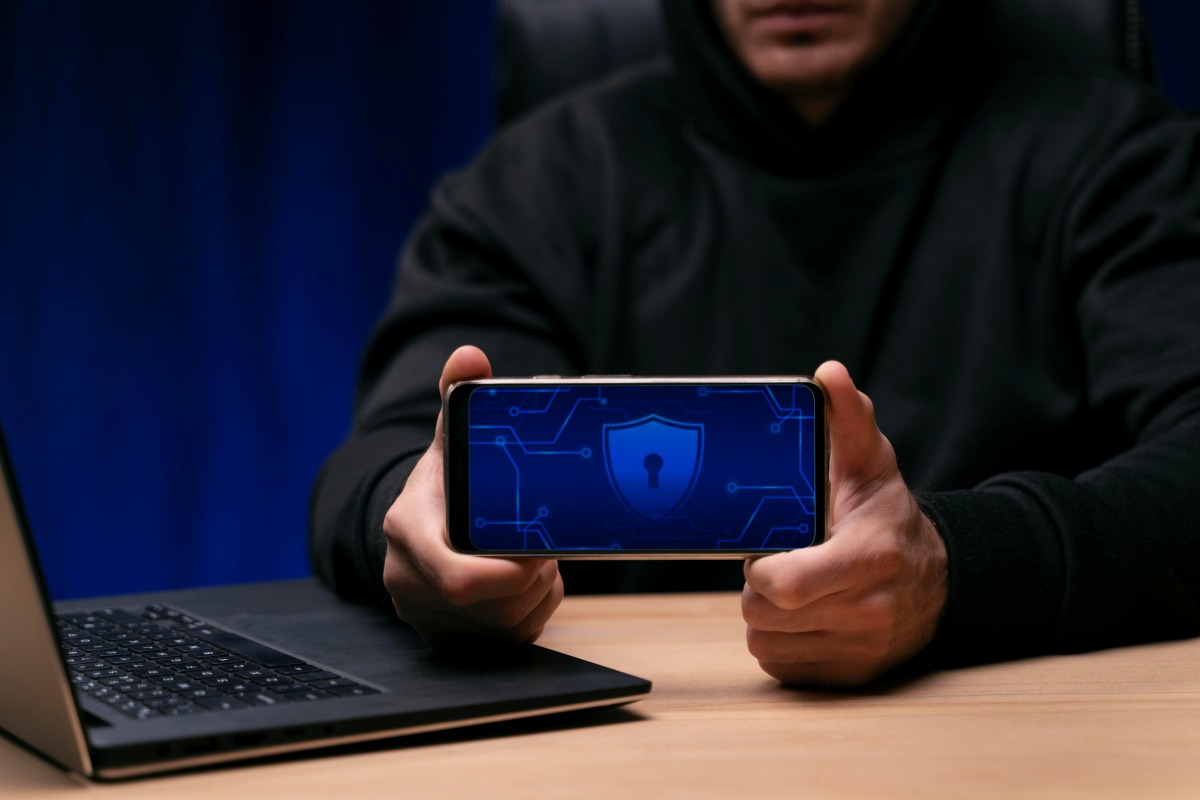 persona-sostiene-celular-con-logo-ciberseguridad