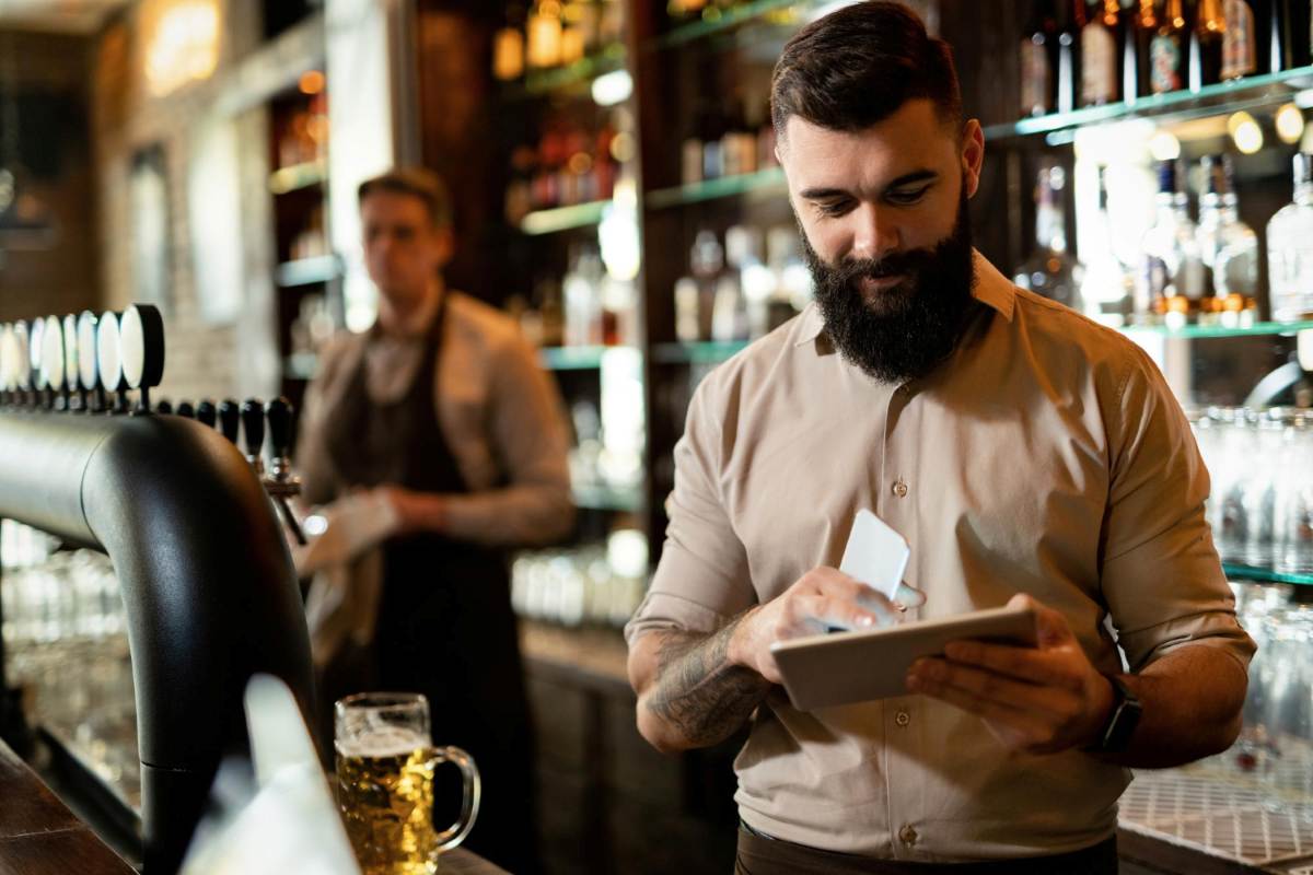persona-usa-tablet-detras-de-barra-de-bar