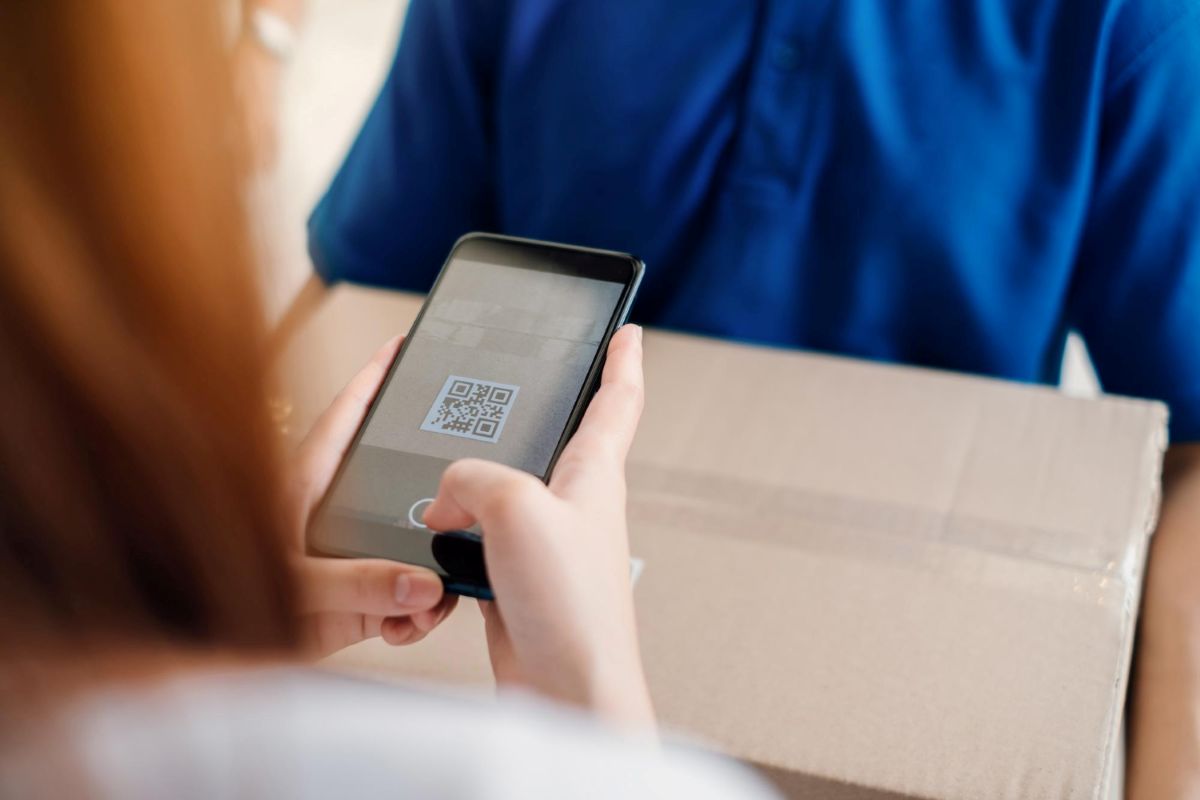 Pessoa lendo QR de caixa de entrega
