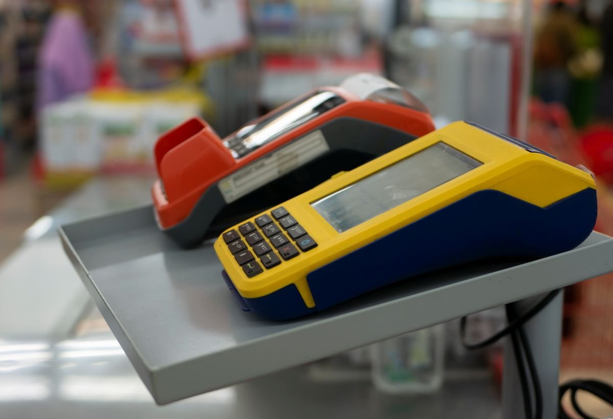 Duas maquininhas de cartão lado a lado sobre o balcão da loja.