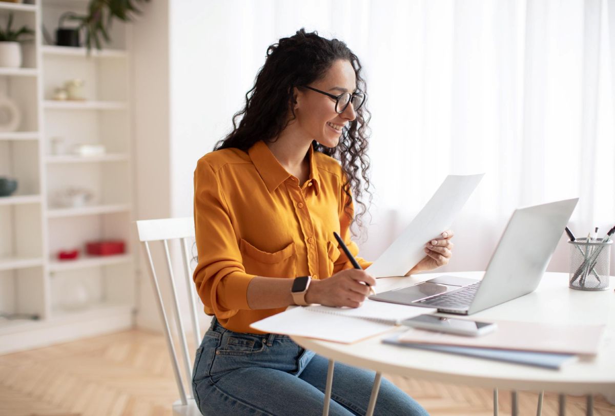 Mulher analisando papéis com relatórios de sua conta