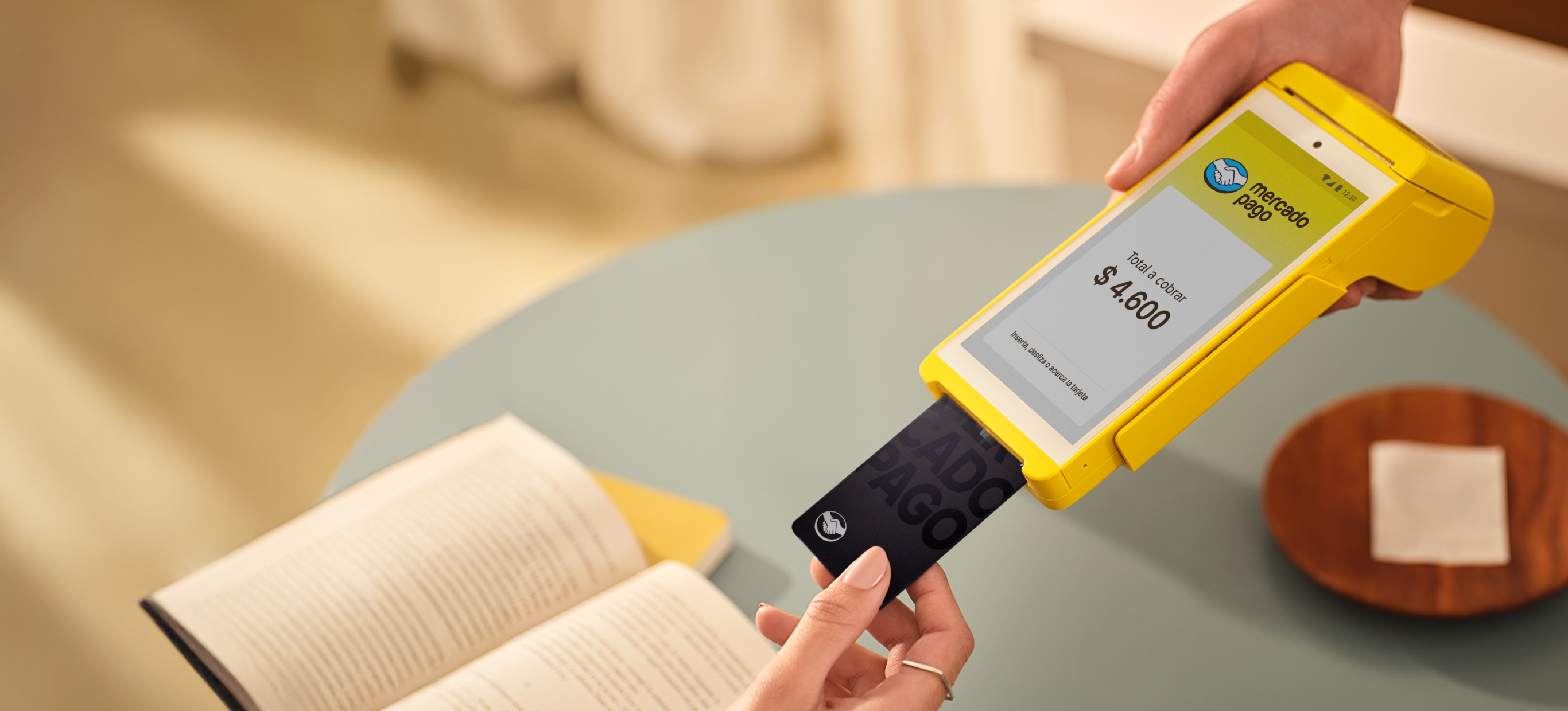Una persona usando la terminal de tarjetas Point para pagar en café.