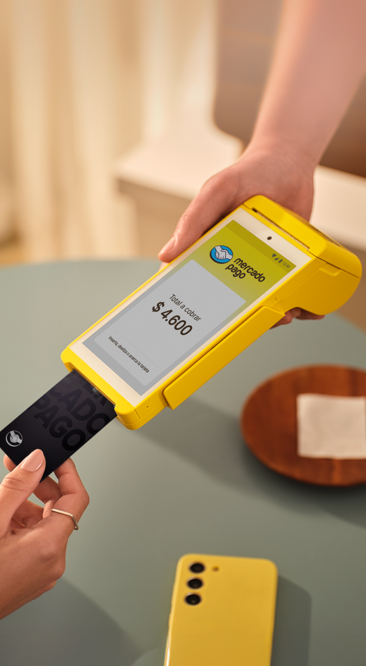 Una persona usando la terminal de tarjetas Point para pagar en café.