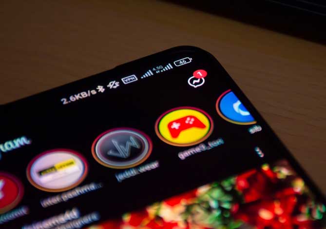 Mercado Pago: Imagem ilustrativa de um celular aberto no Stories do Instagram, apoiado em mesa e perto de teclado de computador