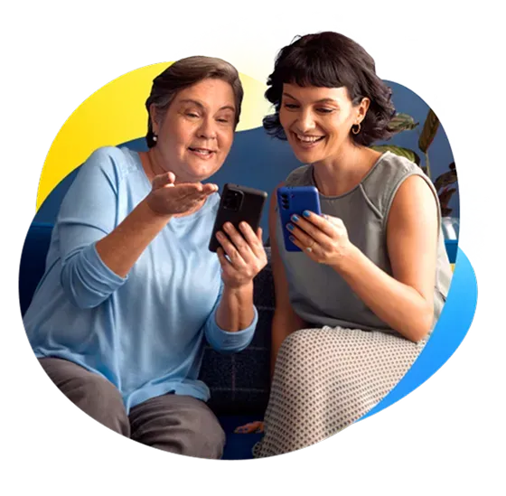 Dos personas se hacen transferencias con sus celulares mientras sonríen