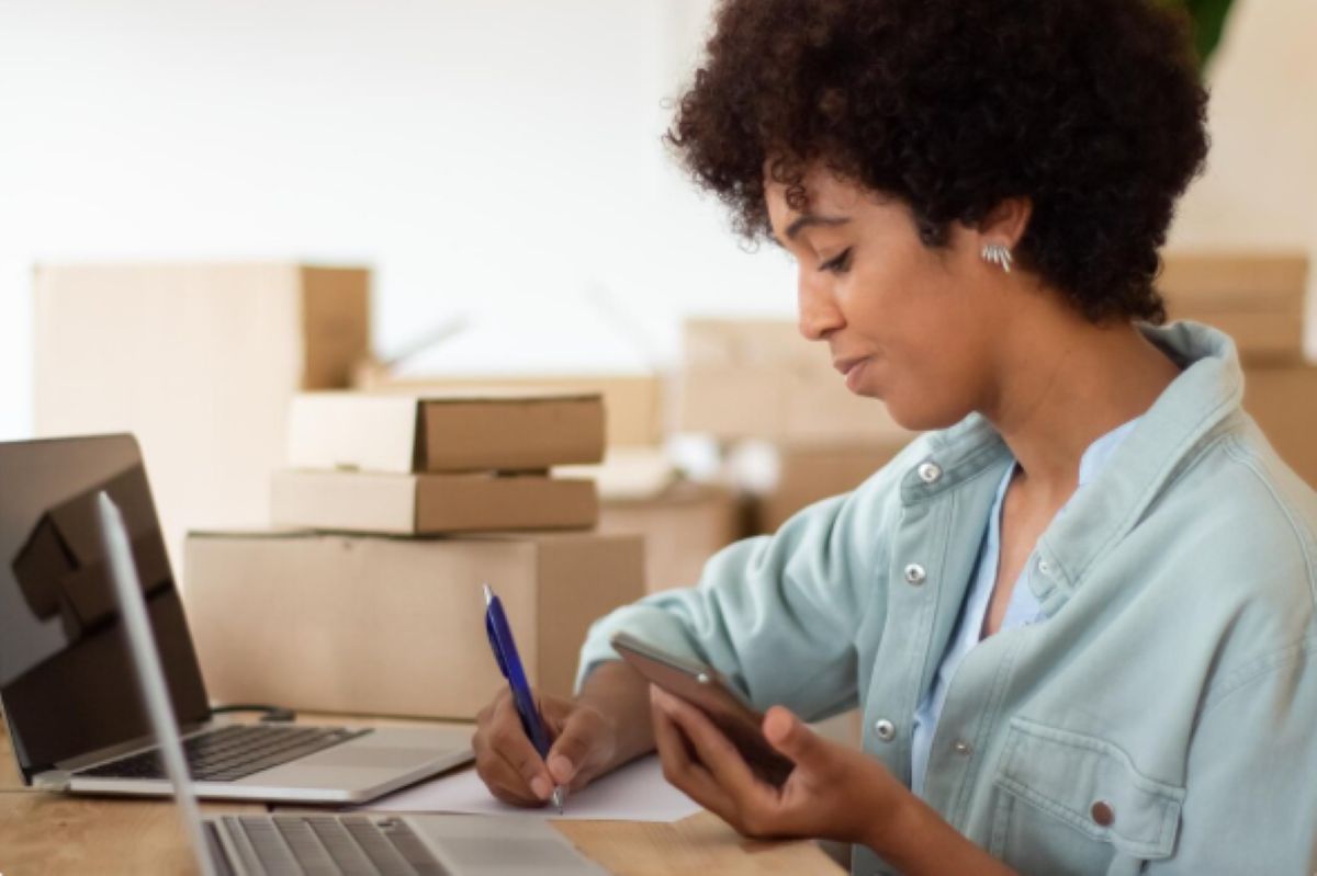 Empresária gerindo vendas online em sua casa.